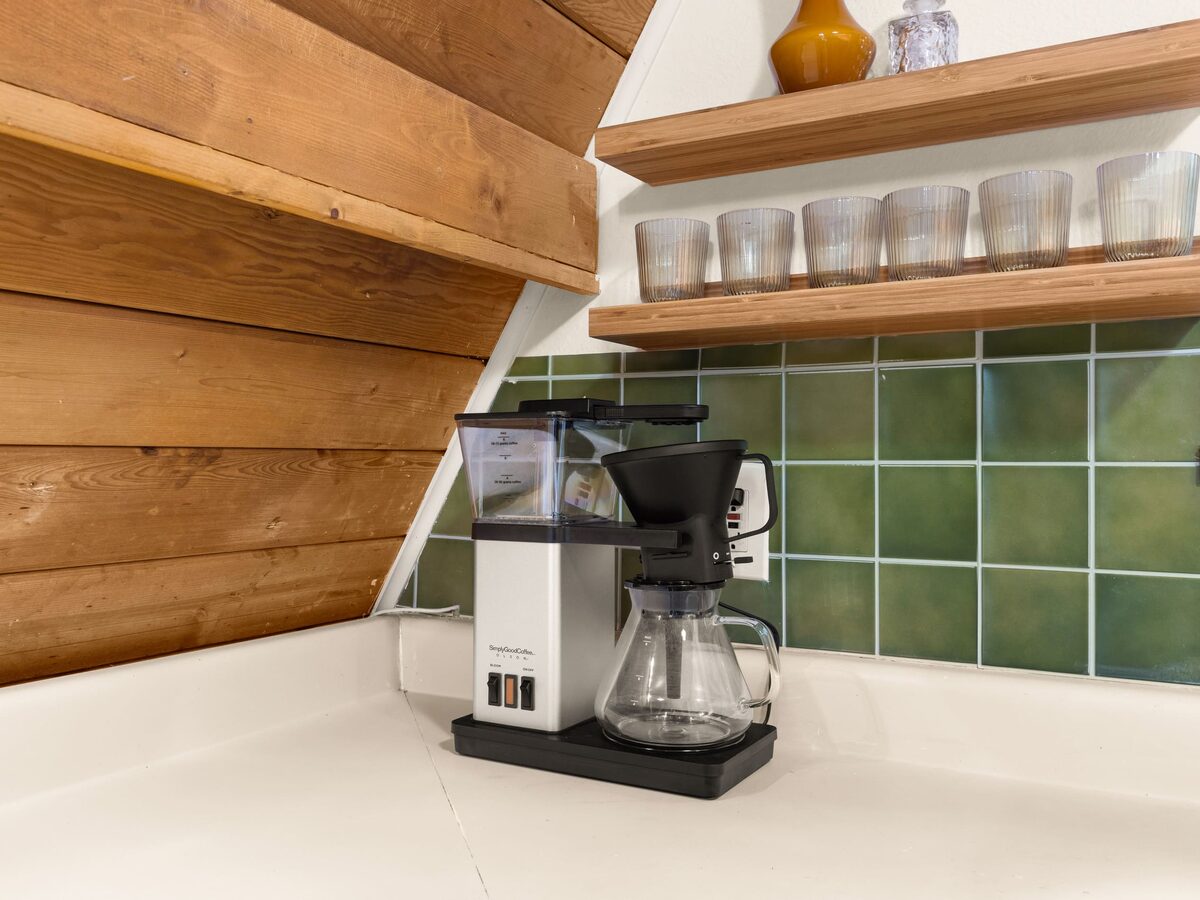 Espresso machine on the kitchen counter against the green tile backsplash