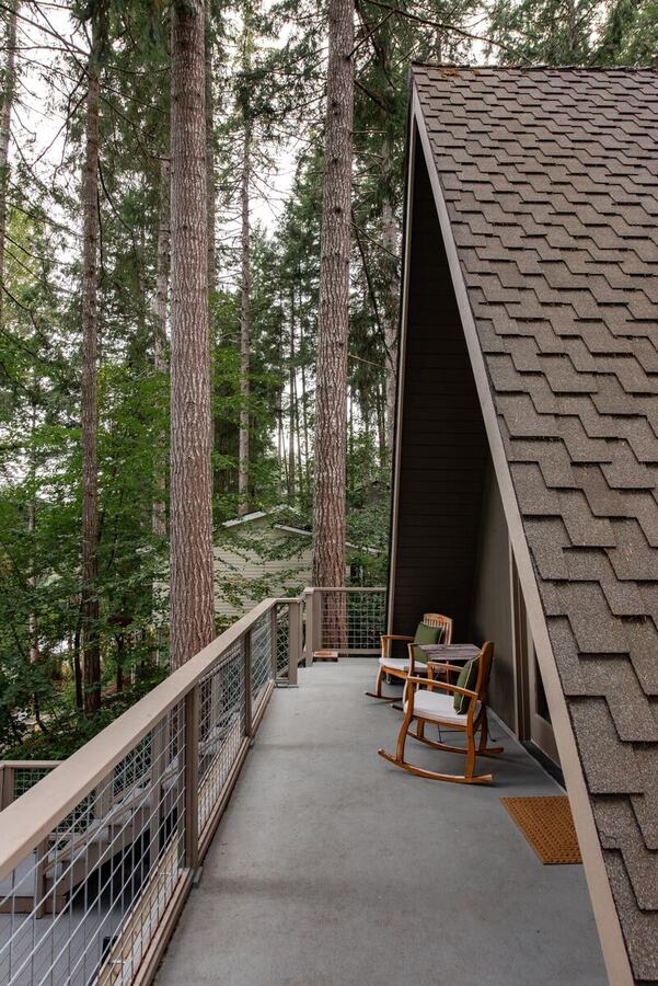 The upper balcony running along the A-frame with a rocking chair