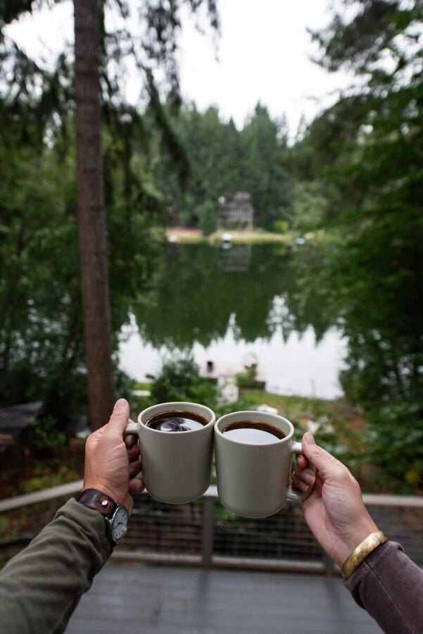 Two mugs of coffee on the balcony rail above Lake Minterwood