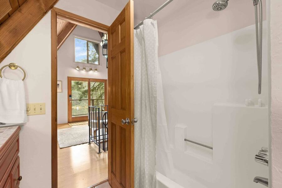 The shower and tub in the full bathroom, looking back toward the main level