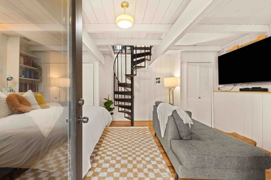 Looking from bedroom one through to the lounge and the spiral staircase