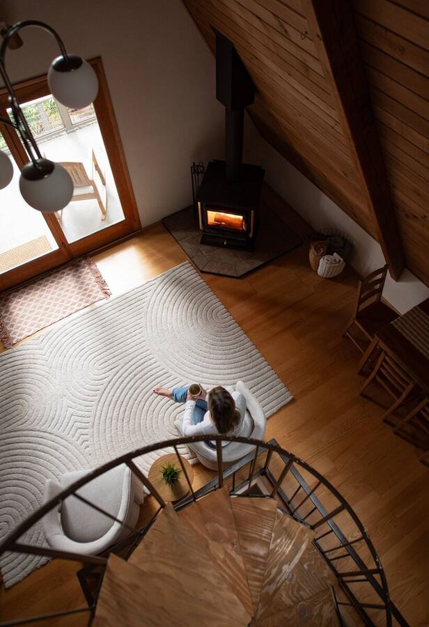 Looking down the black spiral staircase to the wood stove and hardwood floors
