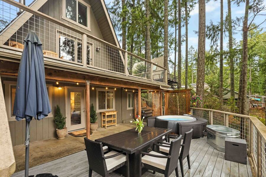 The deck and outdoor dining table along the back of the cabin